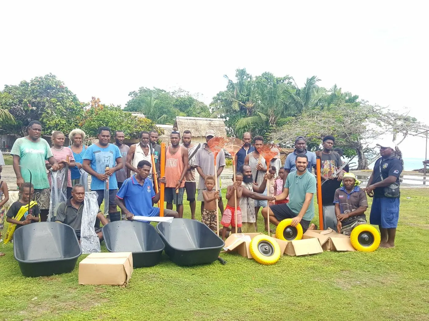 Far right National Healthy Settings Coordinator Mr. Ben Rickie and (second in front row) Dr. Edgar Pollard presented basic clean-up tools to Halavo community on behalf of Rotary Australia, WHO and MHMS.