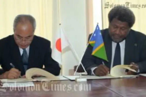 The Japanese Charge' d Affairs, Akira Iwanade and the Minister of Foreign Affairs, William Haomae, during the signing yesterday.