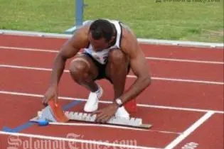 Fiji's Jone Wainiqolo sets his starting block before running the Men's 400m hurdles for which he took the gold medal at 55.12 seconds.