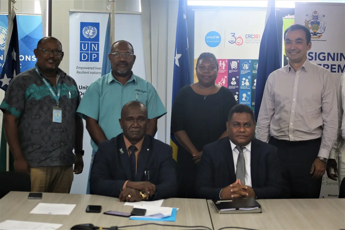 Hon. Seleso (L) and Hon. Ramofafia (R) with their Permanent Secretaries (standing centre) and representatives of the UN.