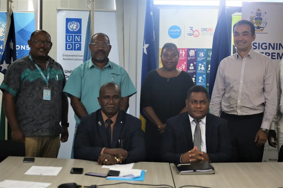 Hon. Seleso (L) and Hon. Ramofafia (R) with their Permanent Secretaries (standing centre) and representatives of the UN.