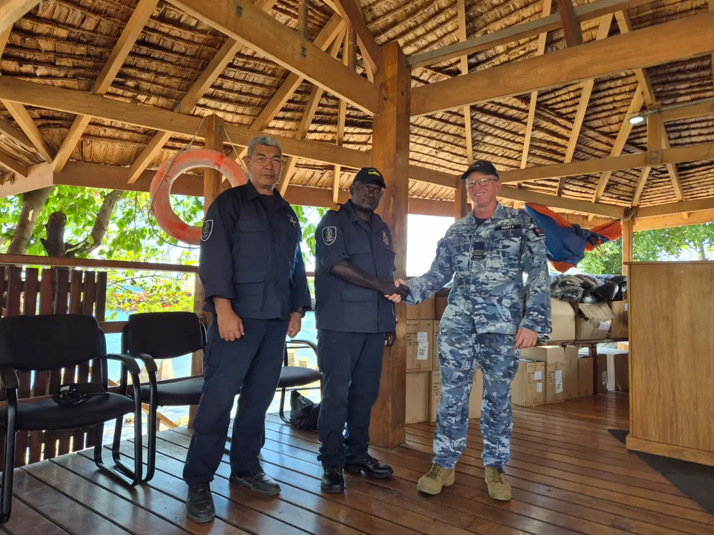 Assistant Defence Advisor Squadron Leader Brett Verity hands over the new working uniforms to RSIPF Maritime Director Nevol Soko and Explosive Ordnance Disposal Director Clifford Tanuki during a ceremony at Aola Wharf.