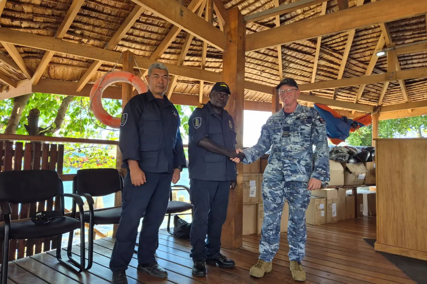 Assistant Defence Advisor Squadron Leader Brett Verity hands over the new working uniforms to RSIPF Maritime Director Nevol Soko and Explosive Ordnance Disposal Director Clifford Tanuki during a ceremony at Aola Wharf.