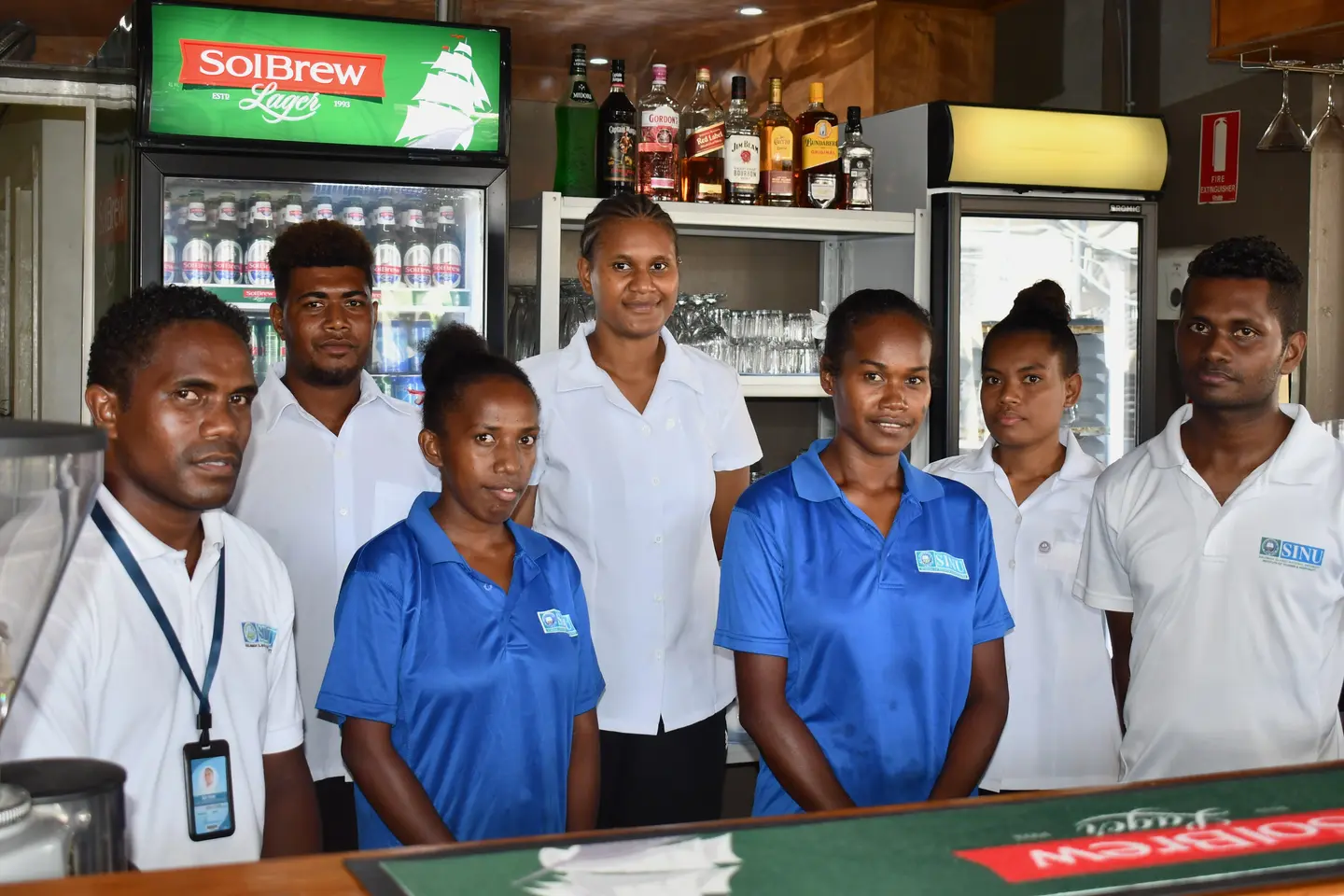 Tina River Hydro CBSP sponsored students, Rita Soloni and Emelda Bineth (in blue shirts) with their colleagues at the SINU-owned Lokol Fusion Café & Bar, where they are currently doing their internship.