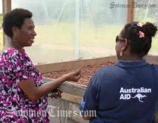 Scholar Aitora from CEMA and Judy Tarailopo of AusAID inspect a solar drier.