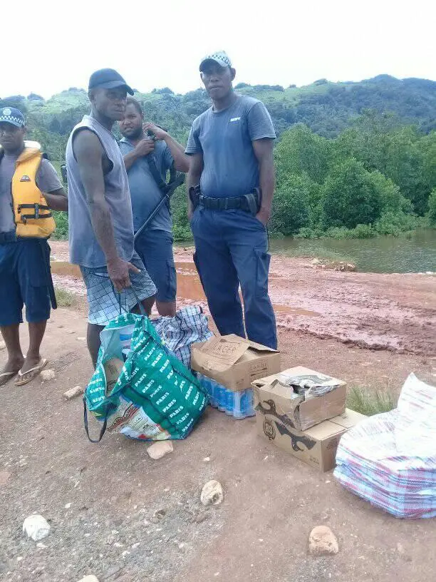 Officers at Atori and community member display some of seized cartons of alcohol
