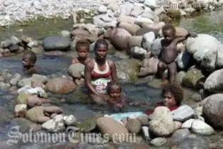 Women and children in a makeshift bath on Guadalacanal.