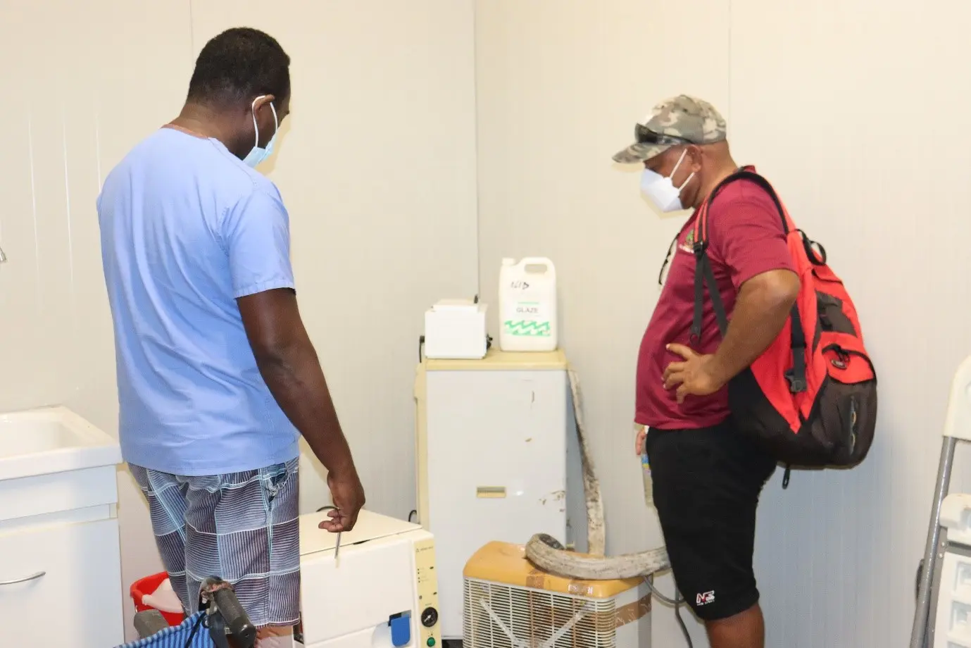 Nila ACH Manager Moses Lamana (left) and NRH Biomedical Engineer Douglas Rerese (right) looking at the Benchtop Sterilizer.