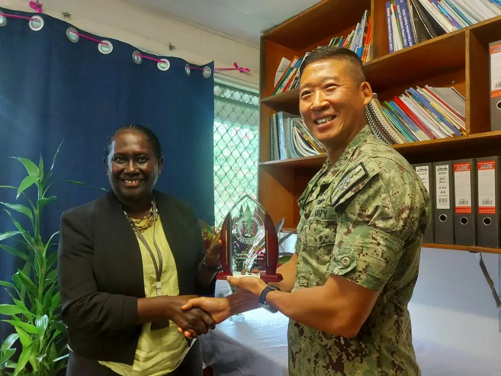 Capt. Henry Kim Commander of the Pacific Partnership Mission presenting gift to the Ministry of Health and received by Health Permanent Secretary, Mrs Pauline McNeil.