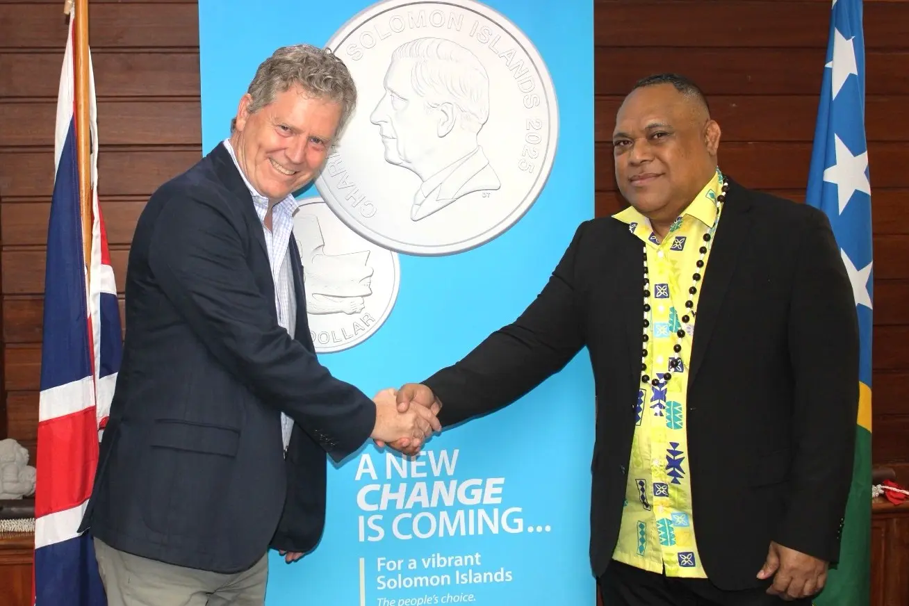 British High Commissioner Paul Turner and Governor of the Central Bank of Solomon Islands Dr Luke Forau shake hands to launch circulation of the 50 cent coin.