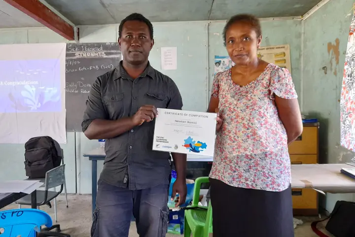 Teachers completed training to use the science teaching tools in the classroom. Catalpa’s Juliet Horihau presents Newton Banisi with a completion certificate.