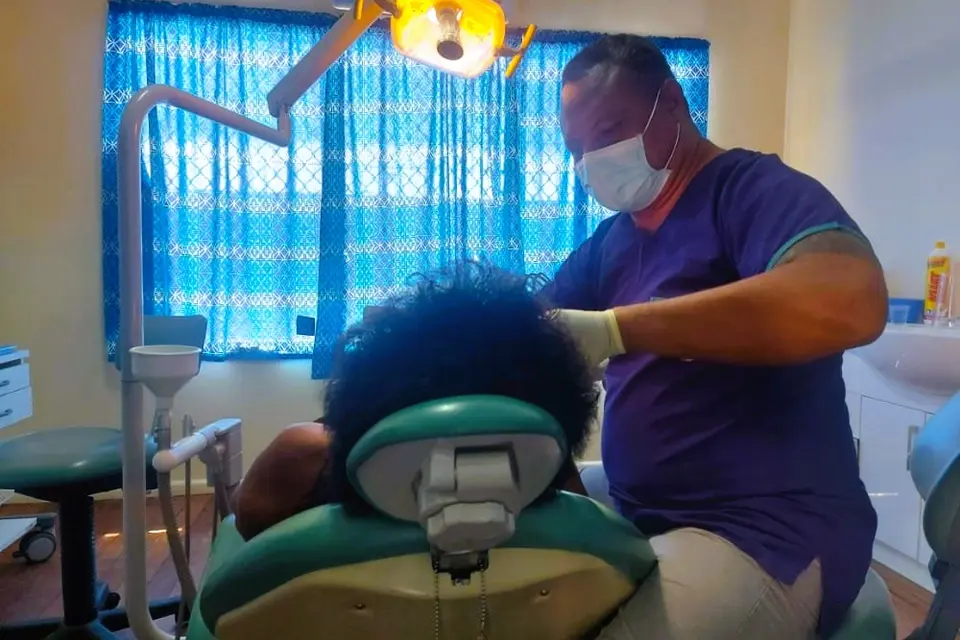 Dentist Dr William Hatingongo attending to a patient with the donated dental chair and equipment.