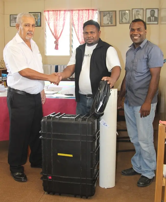 General Manager of SIBC, Ashley Wickham (Left) receiving the mobile radio unit from Lawrence Hillary and Jeremiah Tabua of World Vision.