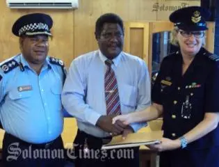 Acting Police Commissioner, Walter Kola, Hon. James Tora and Wing Commander, Wendy Horder handing over the letter of arrangements.